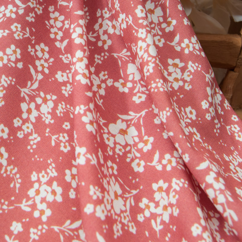 Popeline de viscose fleurie sur fond corail
